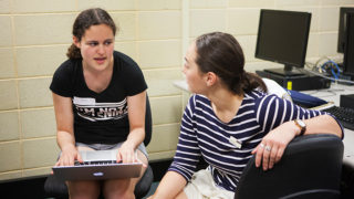 Girl sitting with laptop and mentor